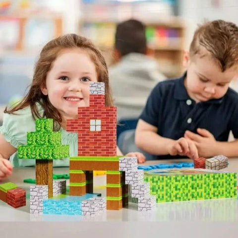 Fillette souriante et garçon concentré construisant une maison et un arbre avec les blocs magnétiques éducatifs Magnaft dans une salle de classe