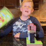 Garçon construisant une structure inspirée de Minecraft avec les blocs magnétiques éducatifs Magnaft, sur une table de cuisine